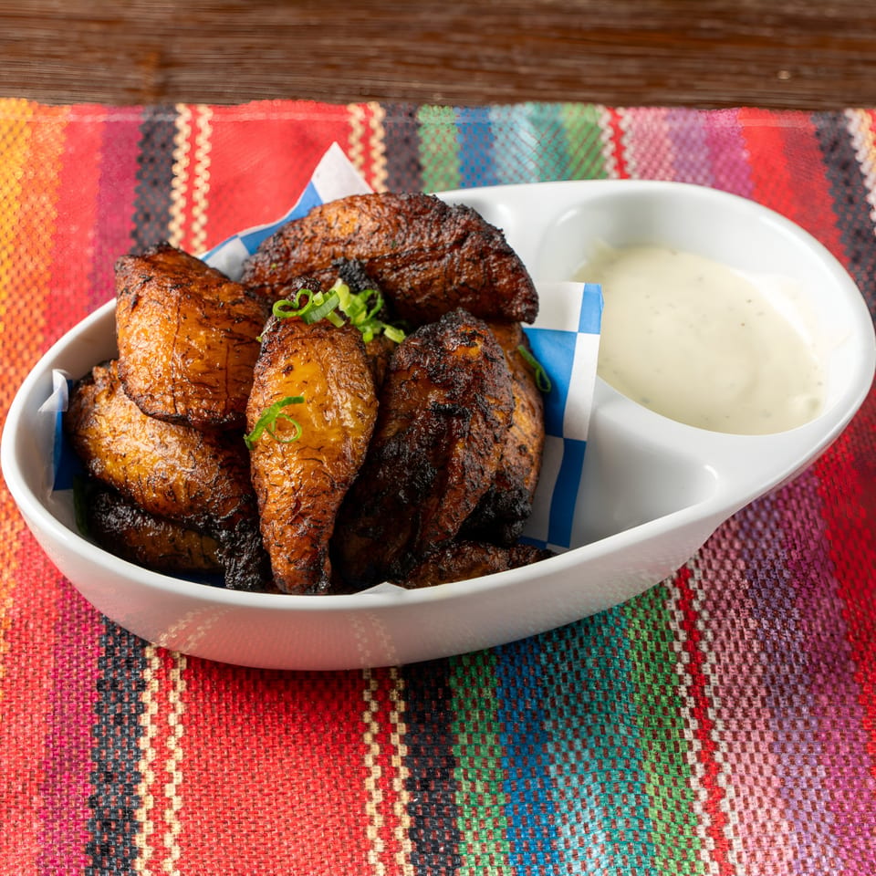 Tipsy Tequila and Taco Bar's fried plantains with green onions and a side of creamy dip.
